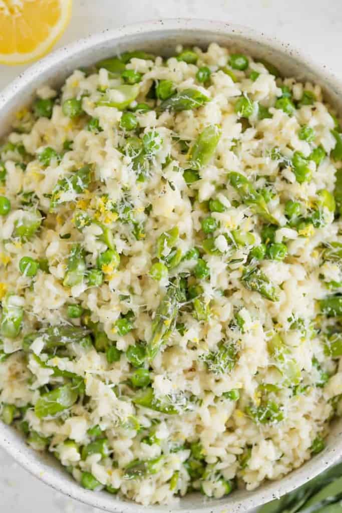 close up of spring risotto with lemon, asparagus, and peas
