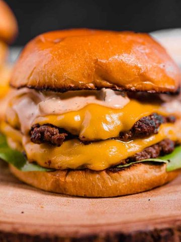close up of a double smash burger with melted cheese on a brioche bun