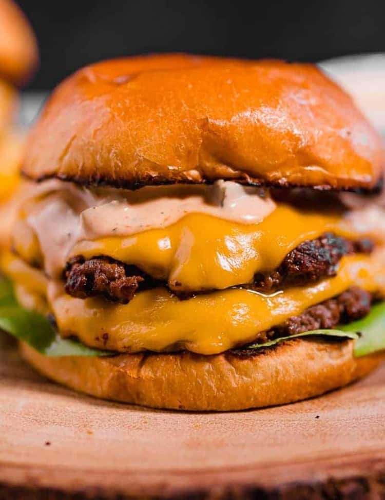 close up of a double smash burger with melted cheese on a brioche bun