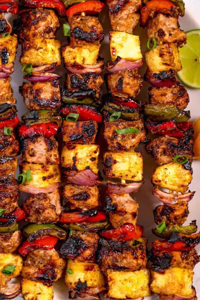 close up of grilled jerk chicken skewers with grilled pineapple
