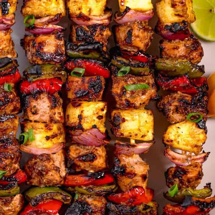 close up of grilled jerk chicken skewers with grilled pineapple