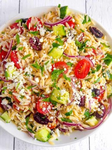 orzo pasta salad with kalamata olives, cherry tomatoes, red onion, feta cheese, cucumbers, tossed in a lemony oregano vinaigrette