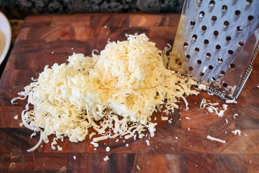 freshly grated Monterey jack cheese on a cutting board