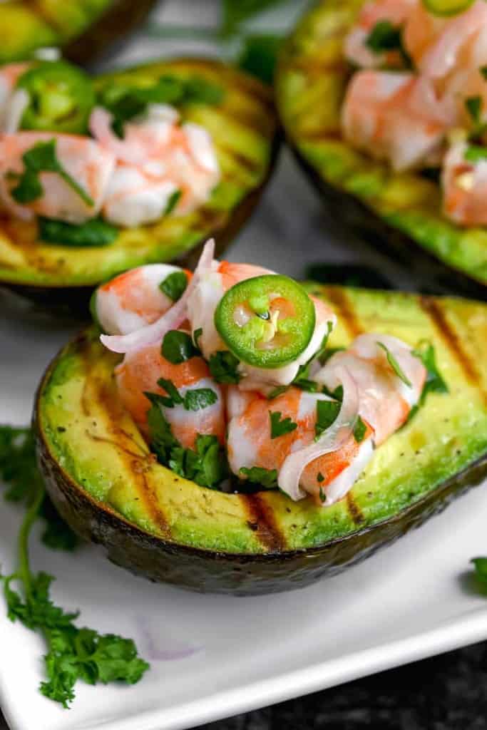 close up seafood inside grilled avocado with serrano pepper on top