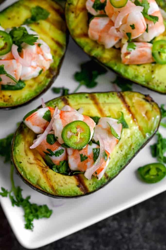 close up of shrimp ceviche inside of a grilled avocado
