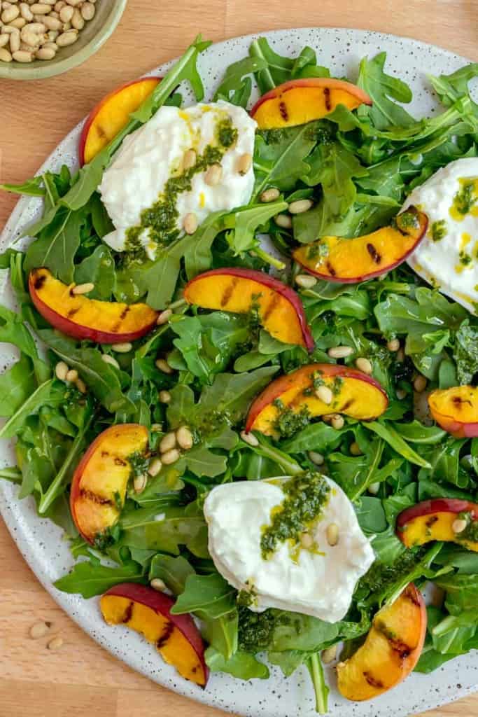 grilled peach and arugula salad with pine nuts and basil dressing