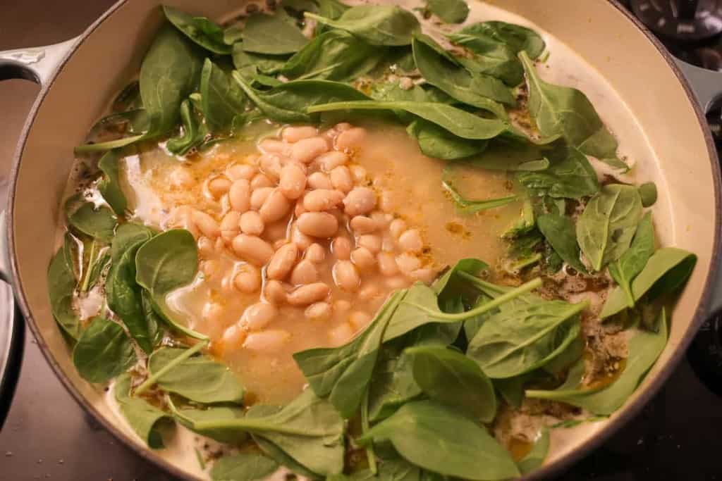 cannellini beans on top of spinach and soup broth