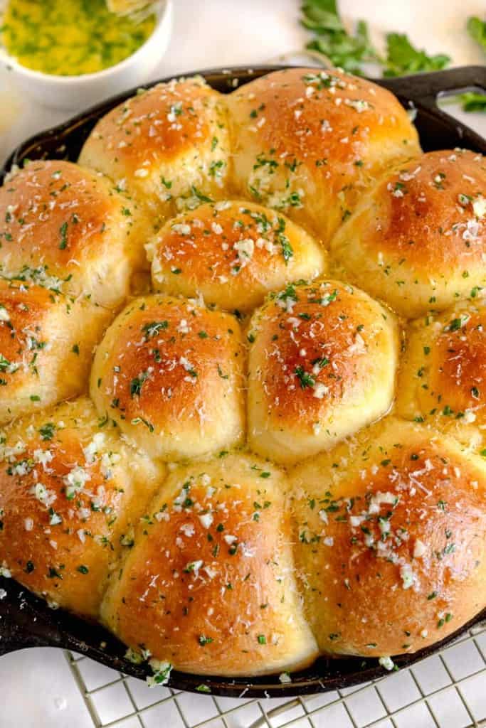 close up of garlic butter dinner rolls in a cast iron skillet