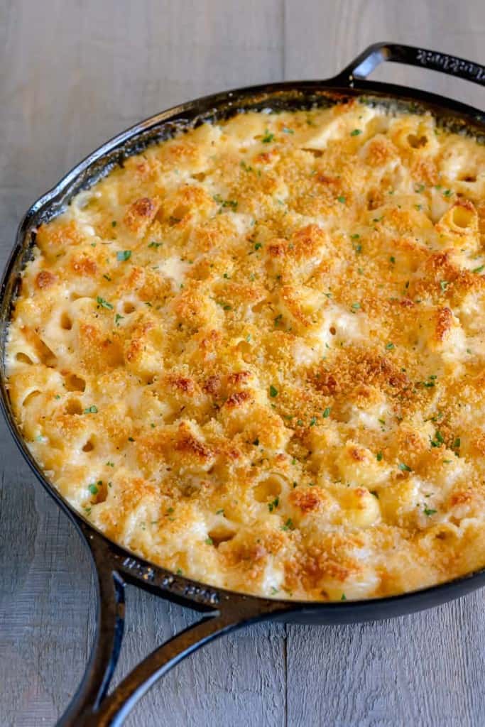 mac and cheese in a cast iron pan topped with golden breadcrumbs