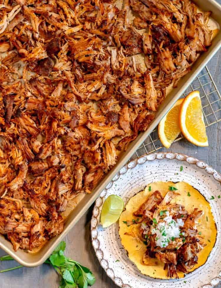 crispy shredded pork on a pan with a charred tortilla and minced onion on top