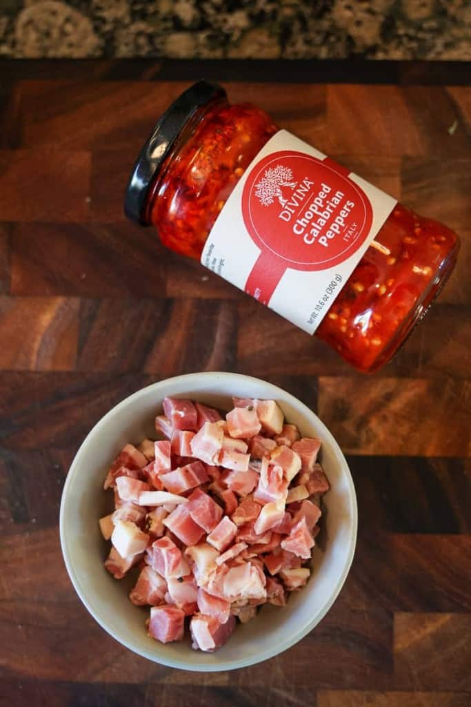 diced pancetta in a bowl and jar of Calabrian chile paste