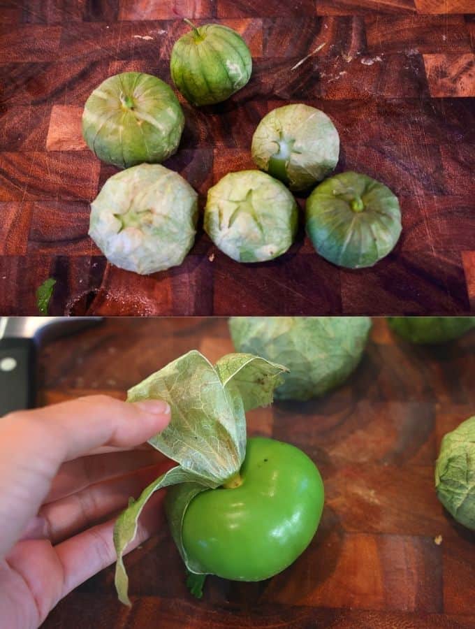 whole tomatillos on a wooden cutting board and pulling the dry husk off
