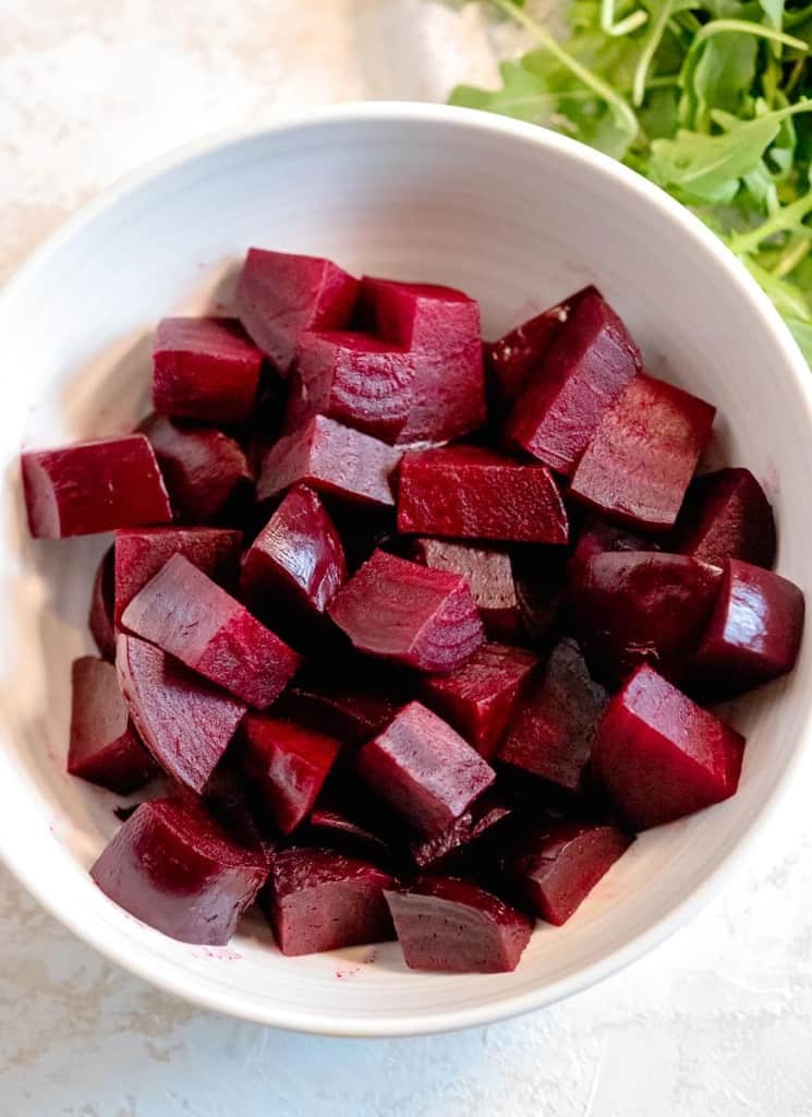 roasted beets quartered in a white bowl