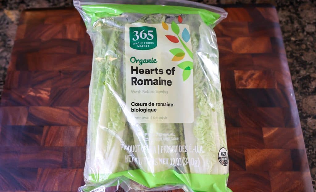 romaine hearts in bag on wooden cutting board
