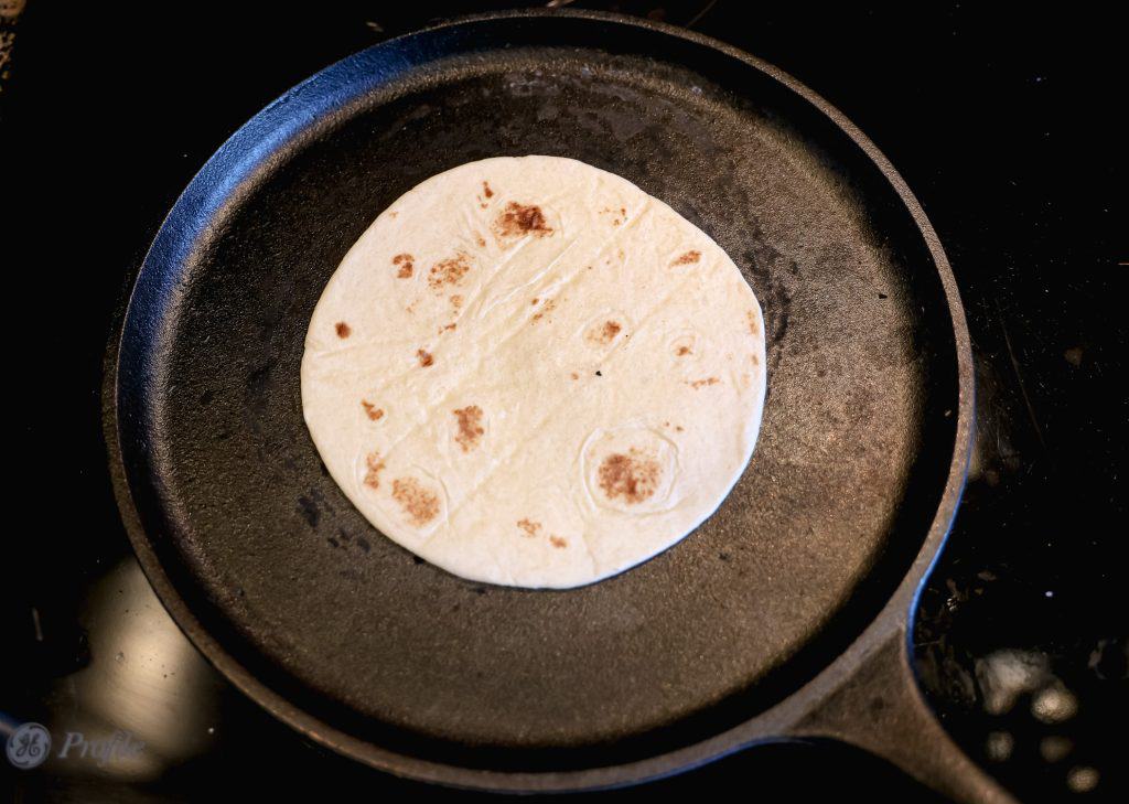 heating a tortilla on a cast iron skillet