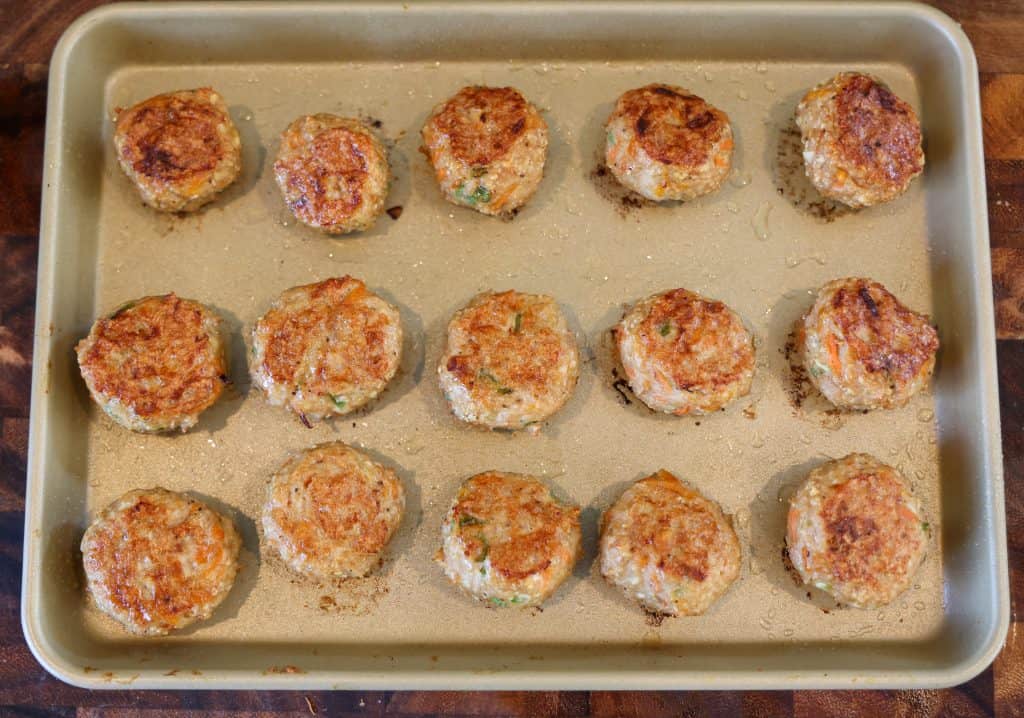 baked chicken meatballs on a golden sheet pan