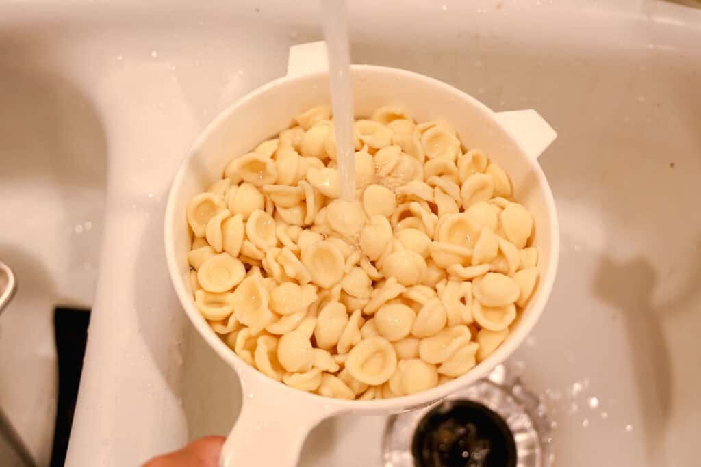 Rinsing pasta under water